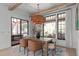 Dining area featuring a modern chandelier, a wood table with seating, and outdoor views at 702 Wimbleton Dr, Raleigh, NC 27609