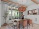 Open dining room featuring a modern chandelier, a wood table with seating, and a scenic outdoor view at 702 Wimbleton Dr, Raleigh, NC 27609