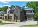 Beautiful home with a stone and wood exterior, featuring a well-maintained lawn and landscaping at 702 Wimbleton Dr, Raleigh, NC 27609