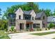 Handsome two-story home featuring brick, stone, and wood accents on a manicured lawn at 702 Wimbleton Dr, Raleigh, NC 27609