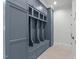 Organized mudroom featuring custom blue cabinetry, bench seating, and storage lockers at 702 Wimbleton Dr, Raleigh, NC 27609