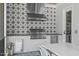 Close-up of the outdoor kitchen with patterned tile, stainless grill, and vent at 702 Wimbleton Dr, Raleigh, NC 27609