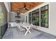 Covered outdoor kitchen and dining area with grill and black trimmed windows at 702 Wimbleton Dr, Raleigh, NC 27609