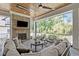 Inviting outdoor living area with a stone fireplace and comfortable seating with wooded views at 702 Wimbleton Dr, Raleigh, NC 27609