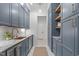 Charming butler's pantry with custom blue cabinets, marble countertops, copper faucet, and stylish decor at 702 Wimbleton Dr, Raleigh, NC 27609