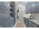 Stylish butler's pantry featuring blue cabinets, open shelving, marble countertops, and modern appliances at 702 Wimbleton Dr, Raleigh, NC 27609