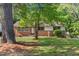 Well-manicured front lawn frames this brick home with mature trees at 717 Fairfield St, Burlington, NC 27215