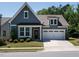 Charming home with blue siding, a two-car garage, manicured lawn, and a welcoming front porch at 725 Banningford Rd, Cary, NC 27518