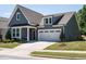 Charming home with blue siding, a two-car garage, manicured lawn, and a welcoming front porch at 725 Banningford Rd, Cary, NC 27518