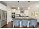Modern kitchen featuring white cabinets, stainless steel appliances, and a dark countertop island with barstool seating at 725 Banningford Rd, Cary, NC 27518