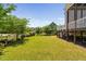 Expansive, well-maintained back yard featuring green grass, mature trees, and partial views of the screened porch at 7700 Stonehenge Farm Ln, Raleigh, NC 27613