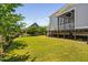The backyard has a well-maintained lawn and a raised deck with a screened porch at 7700 Stonehenge Farm Ln, Raleigh, NC 27613