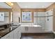 Bright bathroom features a soaking tub, glass shower, and granite counters at 7700 Stonehenge Farm Ln, Raleigh, NC 27613