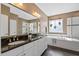 Bright bathroom features a soaking tub, glass shower, and granite counters at 7700 Stonehenge Farm Ln, Raleigh, NC 27613