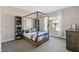 Cozy bedroom with a four-poster bed, a bookshelf, and a view of the outside at 7700 Stonehenge Farm Ln, Raleigh, NC 27613