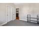 A carpeted room featuring a closet, shelves and an entrance to another room at 7700 Stonehenge Farm Ln, Raleigh, NC 27613