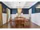 Beautiful dining room featuring a decorative chandelier, hardwood floors, and wainscoting on navy walls at 7700 Stonehenge Farm Ln, Raleigh, NC 27613