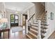 Inviting foyer with hardwood floors, staircase with iron balusters, and elegant black double doors at 7700 Stonehenge Farm Ln, Raleigh, NC 27613