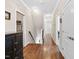 Upstairs hallway with hardwood floors and neutral paint, with access to bedrooms and storage at 7700 Stonehenge Farm Ln, Raleigh, NC 27613