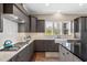 Bright kitchen featuring gray cabinets, a farmhouse sink, and modern stainless steel appliances at 7700 Stonehenge Farm Ln, Raleigh, NC 27613