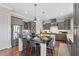 Well-appointed kitchen features a center island with seating, modern appliances, and stylish gray cabinetry at 7700 Stonehenge Farm Ln, Raleigh, NC 27613