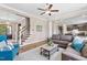 Comfortable living room featuring hardwood floors, a ceiling fan, and an open staircase at 7700 Stonehenge Farm Ln, Raleigh, NC 27613