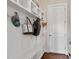 Mudroom with coat hooks, white shelving and seating, providing an organized entryway at 7700 Stonehenge Farm Ln, Raleigh, NC 27613