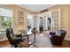 Well-lit office space featuring hardwood floors, a window, and french doors leading to the foyer at 7700 Stonehenge Farm Ln, Raleigh, NC 27613