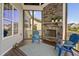 Relaxing screened-in porch with a stone fireplace, Adirondack chairs, and a stylish outdoor rug at 7700 Stonehenge Farm Ln, Raleigh, NC 27613