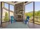 Inviting screened-in porch featuring a stone fireplace, comfortable seating, and tranquil outdoor views at 7700 Stonehenge Farm Ln, Raleigh, NC 27613