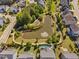 Aerial view of a community pond with a walking path, landscaping, and nearby houses at 7700 Stonehenge Farm Ln, Raleigh, NC 27613