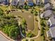 Aerial view of a community pond surrounded by walking paths and beautifully landscaped gardens at 7700 Stonehenge Farm Ln, Raleigh, NC 27613