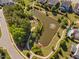 Aerial view of a neighborhood pond and walking path lined with trees and landscaped gardens at 7700 Stonehenge Farm Ln, Raleigh, NC 27613