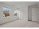 Bright bedroom with carpet, two windows, and a door at 801 Kenyon Spring Dr, Zebulon, NC 27597
