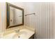 Half bath features a decorative mirror and patterned wallpaper at 8409 Crowder Rd, Raleigh, NC 27603