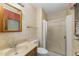 Cozy bathroom featuring patterned wallpaper, a vanity with mirror, and a shower with glass doors at 8409 Crowder Rd, Raleigh, NC 27603