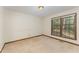 Bright bedroom filled with natural light from large windows, featuring neutral walls and carpeted flooring at 8409 Crowder Rd, Raleigh, NC 27603