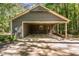 Open garage featuring gray wood paneling with ample parking space and pedestrian doors at 8409 Crowder Rd, Raleigh, NC 27603