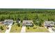 An aerial view of a two-story home with an attached two-car garage surrounded by a green lawn and mature trees at 870 Kentucky Derby Ln, Lillington, NC 27546