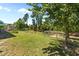 Lush backyard featuring mature trees, fenced garden and a bench-lined fire pit at 870 Kentucky Derby Ln, Lillington, NC 27546