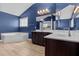 Bright bathroom featuring blue walls, a double vanity, modern lighting, and a jacuzzi bathtub at 870 Kentucky Derby Ln, Lillington, NC 27546