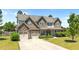 Charming two-story home featuring a stone facade, multi-car garage and a well-manicured lawn at 870 Kentucky Derby Ln, Lillington, NC 27546