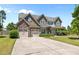 Charming two-story home featuring a stone facade, multi-car garage and a well-manicured lawn at 870 Kentucky Derby Ln, Lillington, NC 27546