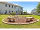 Inviting backyard fire pit featuring built-in seating and a charming brick border, perfect for outdoor gatherings at 870 Kentucky Derby Ln, Lillington, NC 27546