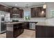 Well-lit kitchen with dark cabinetry, stainless steel appliances, granite countertops, and an island at 870 Kentucky Derby Ln, Lillington, NC 27546