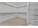 Walk-in closet showcasing multiple shelves, installed rods for clothing, and carpet flooring at 870 Kentucky Derby Ln, Lillington, NC 27546