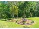 Backyard features a fountain surrounded by landscaped flowerbeds and mature shade trees at 8733 Crowder Rd, Raleigh, NC 27603