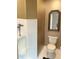Elegant half bath with a classic mirror, neutral wallpaper, a urinal, and tiled accents at 8733 Crowder Rd, Raleigh, NC 27603