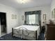 Inviting bedroom with a wrought iron bed frame, soft lighting, and coordinated window treatments at 8733 Crowder Rd, Raleigh, NC 27603