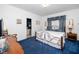Cozy bedroom featuring a metal-framed bed, blue carpet, and an ensuite bathroom at 8733 Crowder Rd, Raleigh, NC 27603